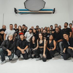 A large group of photographers gathered in a brightly lit photo studio, showcasing diversity and creativity.