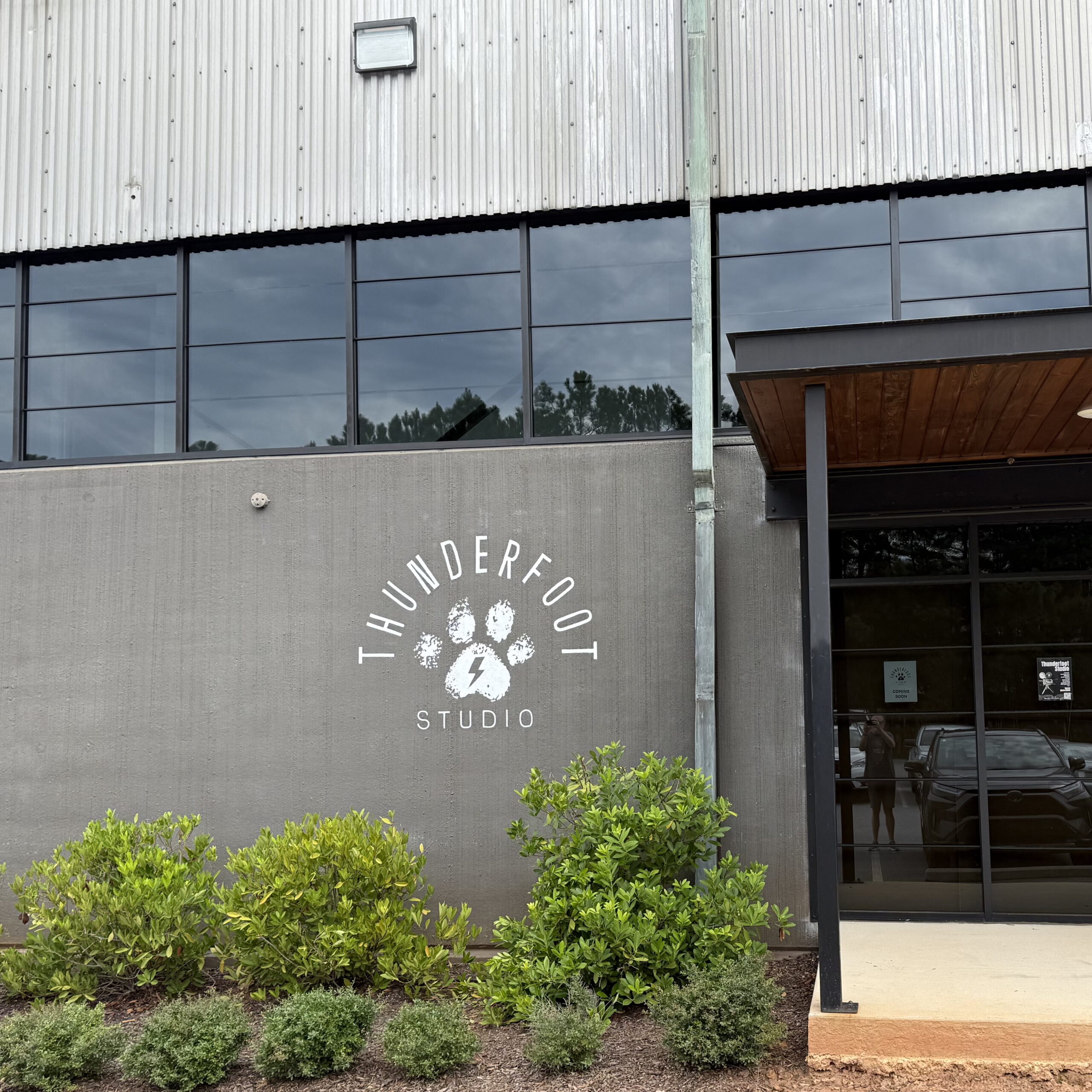 A dark wall painted with a white Thunderfoot paw-print logo that reads "Thunderfoot Studio"